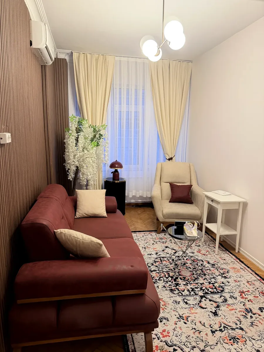 Ahşap panelli duvarı, bordo koltuğu ve perdeli penceresiyle görüşme odası